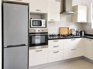 A modern kitchen with a Brandt refrigerator, a microwave, an oven, and a gas stove. - Gammarth Luxury Retreat - Villa with Private Pool & Garden High Standing (Gammarth)