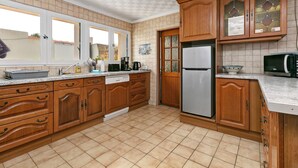 Une cuisine dotée de meubles en bois, d’un réfrigérateur en acier inoxydable, d’un four à micro-ondes et d’un lave-vaisselle.
