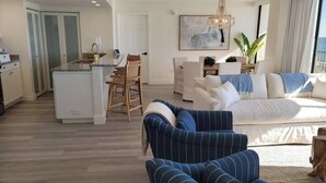 Ein zeitgemäßer Wohnraum mit Küche, Essbereich und einem großen Bett.
