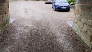 Ein Schotterweg führt zu einem Gebäude mit einem steinernen Bogen, der mit 'LOW ARCH 6' 11 beschriftet ist.