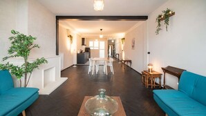 A spacious living area with a wooden coffee table, two sofas, a dining table, and a kitchen in the background. - 2BR Apartment Near Grand Central Station (Antwerp)
