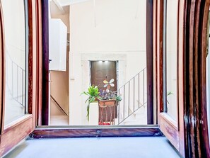 Eine Treppe führt zu einer Zwischenebene mit einem dekorativen Lüfter und Topfpflanzen.