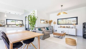 Een moderne woonruimte met een eethoek, een bank en een keuken.