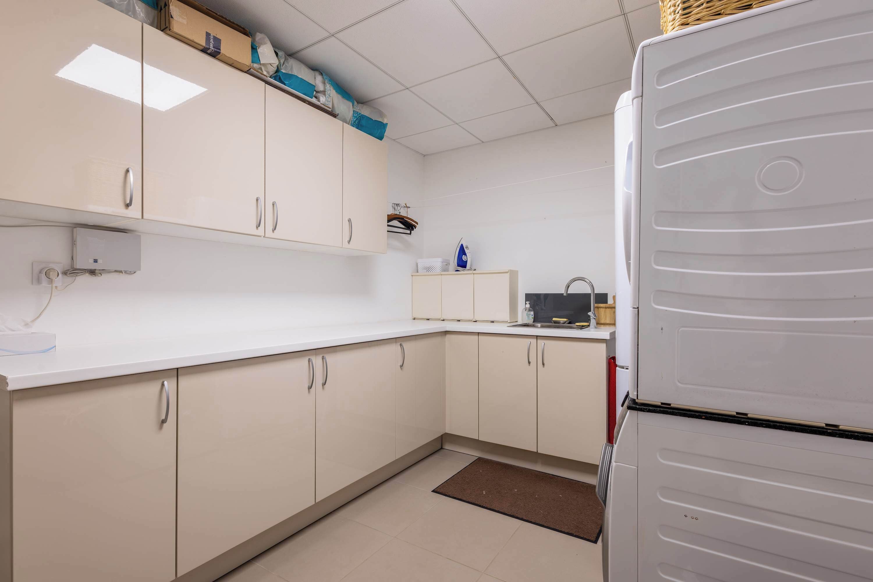 A kitchen with white cabinets, a refrigerator, and a microwave.