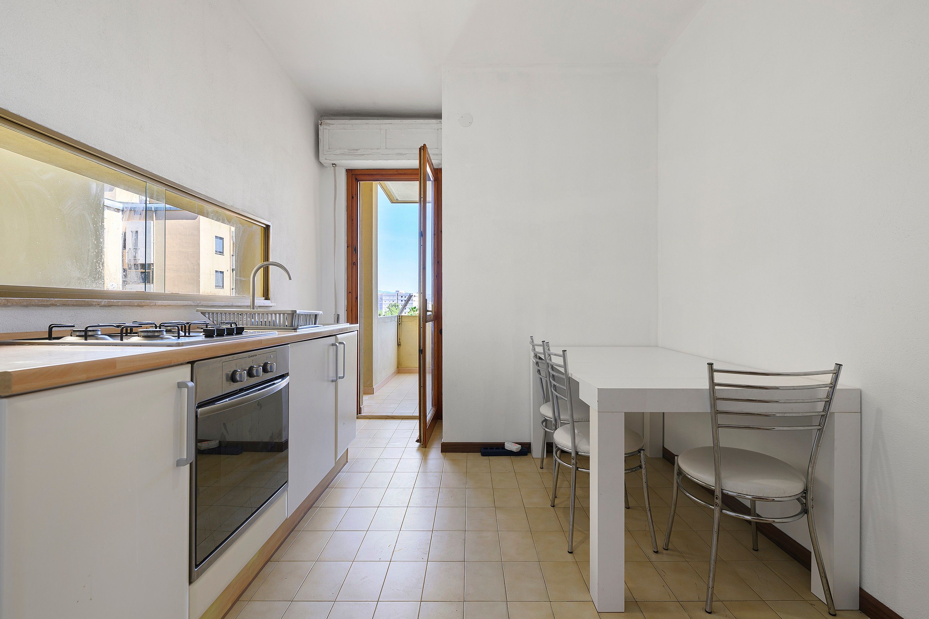 Una cucina funzionale con piano cottura a gas, forno e un'area pranzo con tavolo e sedie.