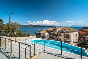 A swimming pool with a view of a coastal town and mountains. - Apartment 'Danai Luxury Suite' with Balcony, Wi-Fi and Air Conditioning (Lefkada)
