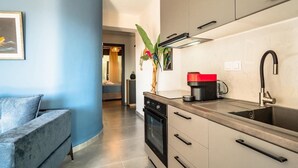 A modern kitchen with a built-in oven, a coffee machine, and a sink.
