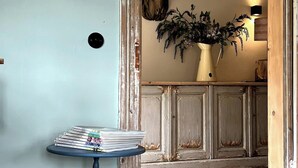 A room with a rustic door frame, a small table with a vase, and a wall-mounted decorative horse head.