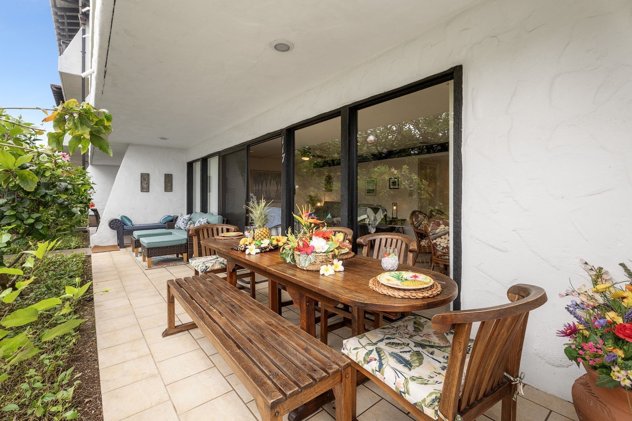 An outdoor dining area with a wooden table, chairs, and a bench.