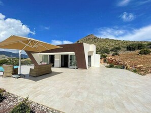 A modern villa with a pool, outdoor seating, and a view of the surrounding landscape. - Mediterranean villa with panoramic infinity pool (Castellammare del Golfo)