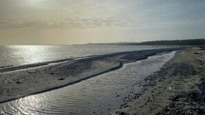 Una spiaggia con cielo sereno e sole splendente.