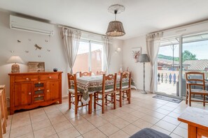 Ein Essbereich mit Holztisch und Stühlen, einem Schrank und einer Deckenleuchte.