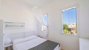 A bedroom with a bed, a bedside table, a window, and a curtain. - Villa with terraces on Castellammare Gulf (Alcamo)
