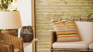 A wicker chair with a striped pillow, a wicker lamp, and a wicker basket on a white table. - Villa with terraces on Castellammare Gulf (Alcamo)