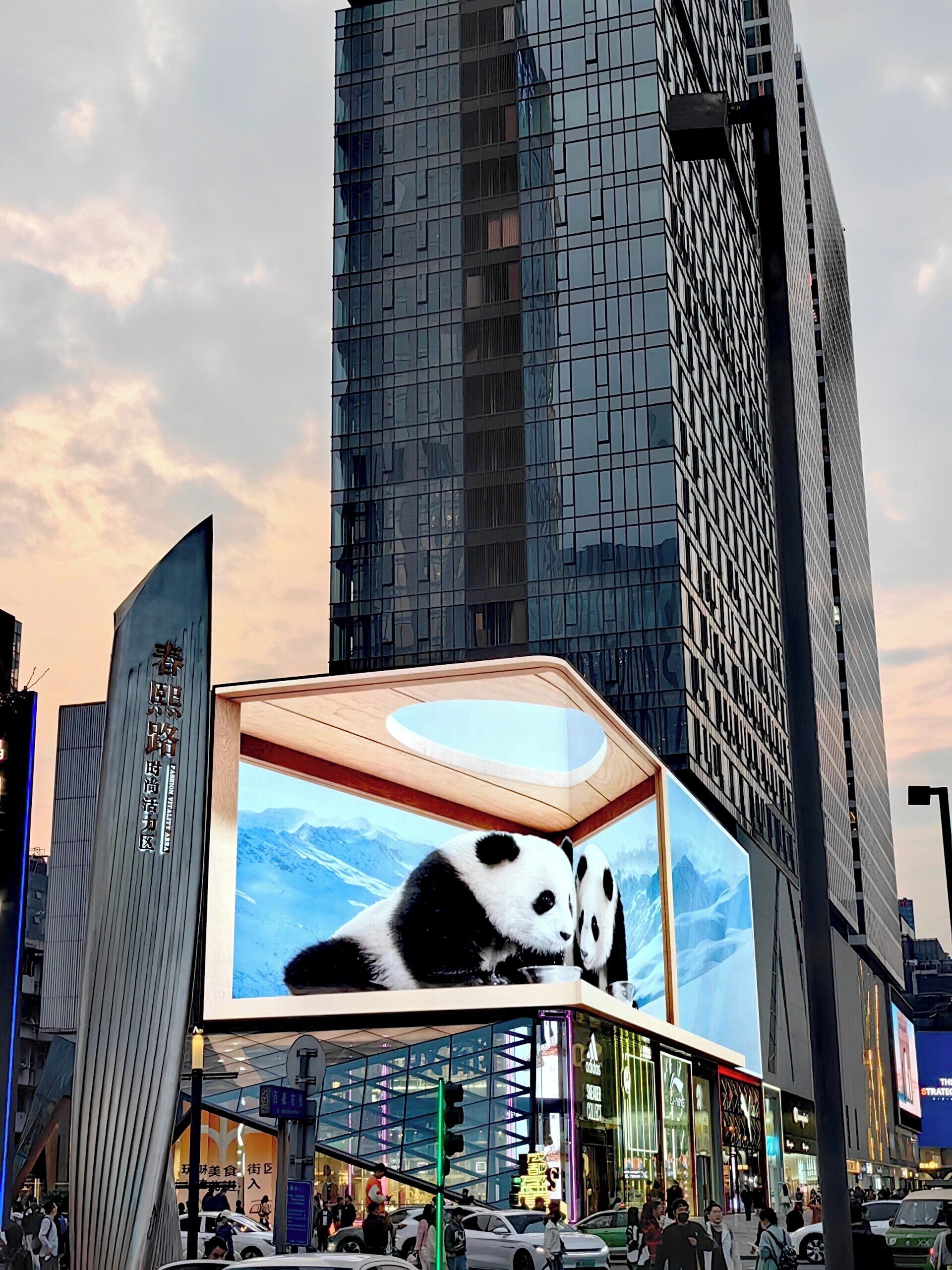 Un edificio moderno con un grande cartellone pubblicitario raffigurante un panda sulla facciata.