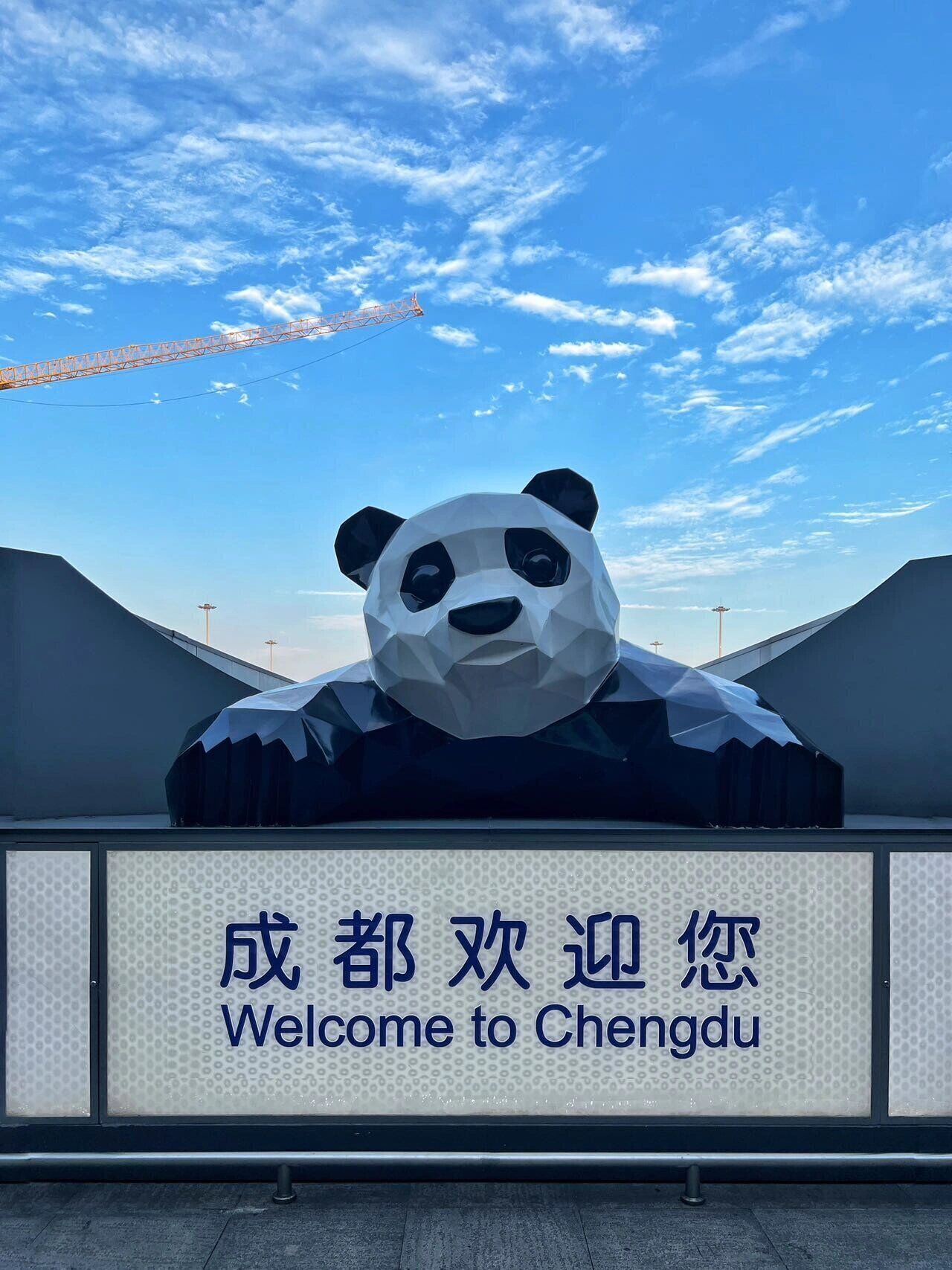 Eine große Pandal-Skulptur mit einem Schild, auf dem 'Welcome to Chengdu' in chinesischer und englischer Sprache steht.