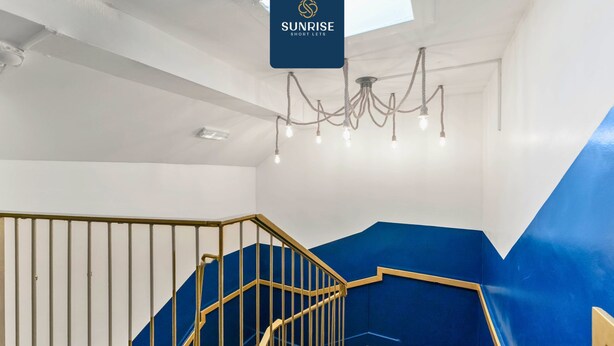 A staircase with blue walls and a chandelier. - Spacious 4BR City Centre Apartment Dundee (Dundee)
