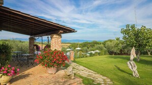 A patio with outdoor furniture, a brick column, and a potted plant. - Apartment with view of Lake Trasimeno (Castiglione del Lago)