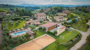 A residential area with a tennis court, a swimming pool, and a large building with multiple rooms. - Apartment with view of Lake Trasimeno (Castiglione del Lago)