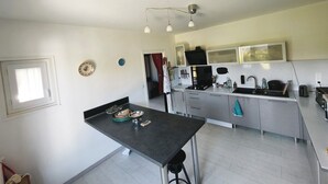 Una cocina con una mesa de comedor, armarios, un lavamanos y una ventana.