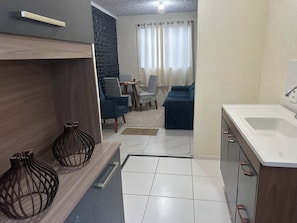 A modern kitchen with a sink, cabinets, and decorative vases. - Apartment for groups "MARGARIDA" Rio de Janeiro, quiet location. (Rio de Janeiro)