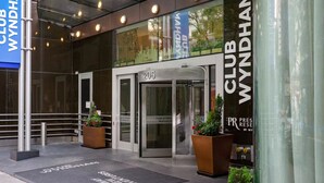 Der Eingang zum Club Wyndham, mit einer Glastür, einer Metalltreppe und einem Schild mit der Adresse.