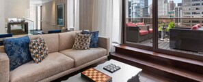 A modern living room with a sofa, patterned cushions, a chessboard, and a view of the city through large windows. - CLUB WYNDHAM 45 - JULY 4 WEEKEND! - STUDIO in amazing MIDTOWN NYC with kitchen (New York)