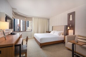A hotel room with a bed, desk, chair, and a view of buildings through the window. - CLUB WYNDHAM 45 - JULY 4 WEEKEND! - STUDIO in amazing MIDTOWN NYC with kitchen (New York)