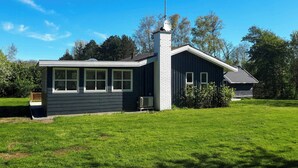 A two-story house with a chimney, a satellite dish, and a well-maintained lawn.