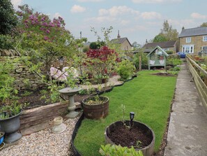 A garden with a stone wall, various potted plants, a birdbath, and a lawn. - Banklands (Barnard Castle)