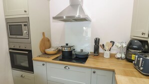 A compact kitchen with a microwave, oven, stove, and a coffee maker. - Banklands (Barnard Castle)