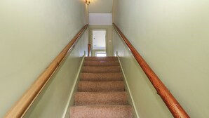 A carpeted staircase with wooden handrails and a light green wall. - Banklands (Barnard Castle)