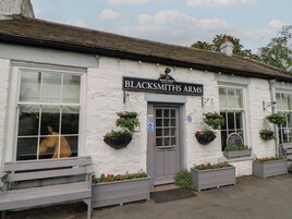 Un edificio blanco con un letrero que dice 'Blacksmiths Arms'.