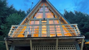 Une structure triangulaire en bois, dotée d’un balcon et d’une entrée en treillis.