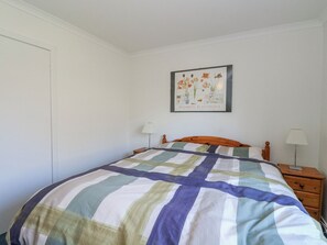 A bedroom with a bed, a nightstand, a lamp, and a framed picture on the wall. - Grianach (Pitlochry)