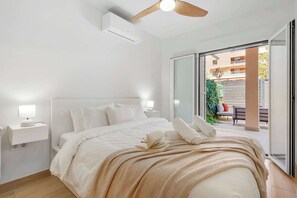 A bedroom with a bed, bedside lamps, a ceiling fan, and a sliding glass door to an outdoor area. - Modern 2BR Marbella Centre Pool & Terrace (Marbella)
