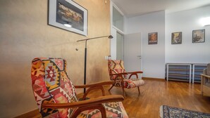 A living room with patterned chairs, a standing lamp, and a framed picture on the wall. - San Siro Suite – Elegant Room Near San Siro (With Host) (Milan)