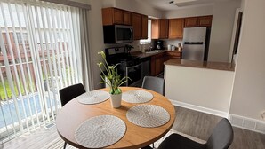 A modern kitchen with wooden cabinets, a stainless steel refrigerator, and a microwave. - This beautiful 3-bedroom condo in Painesville has the comforts of home, elevated (Painesville)
