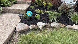 A residential property with a brick facade, numbered 282 and 280, a front yard with a flower bed, and a garage. - This beautiful 3-bedroom condo in Painesville has the comforts of home, elevated (Painesville)