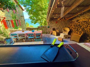 Un espace extérieur am énagé pour les repas, avec un mur en pierre, du mobilier en bois et une vue sur les montagnes.