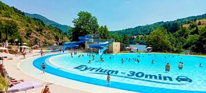 Une piscine avec un toboggan et une vue sur un lac entouré de collines.