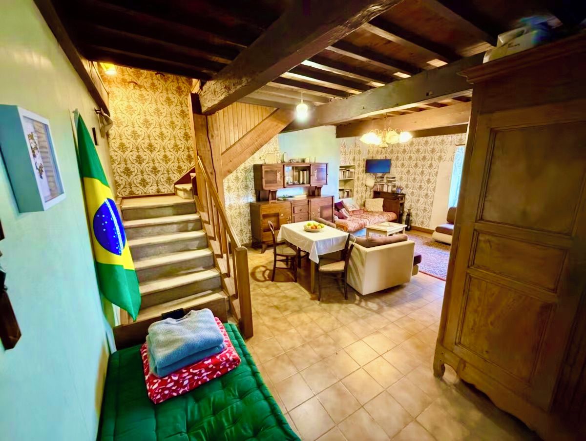 Una habitación con escalera, comedor y cocina.