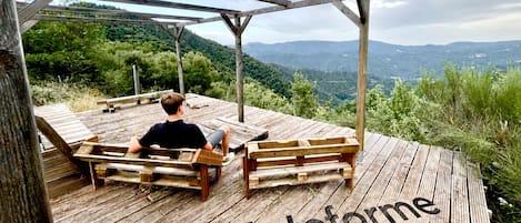 A wooden deck with benches and a person sitting. The deck has 'La plateforme' written on it.