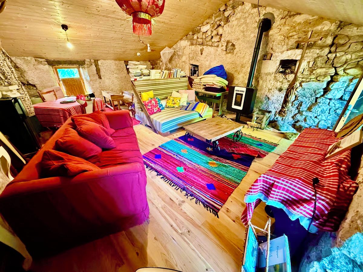 A cozy room with a red sofa, a wooden coffee table, and a colorful rug.
