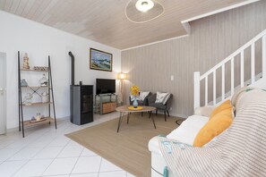 A living room with a sofa, a TV, a fireplace, and a staircase. - Seaside Escape by the Petite Mer de Gâvres (Plouhinec)