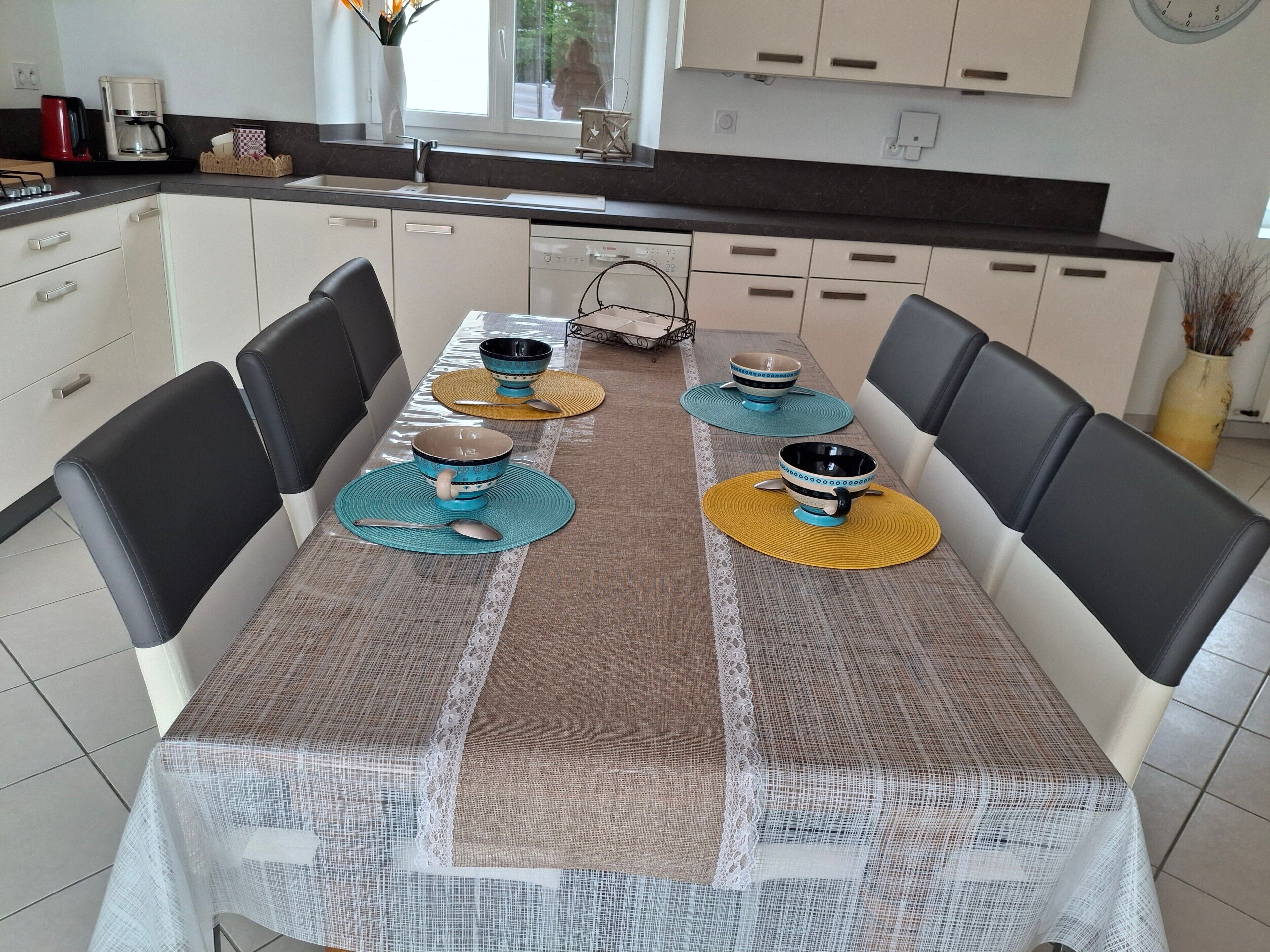 A dining table with placemats, chairs, and bowls.