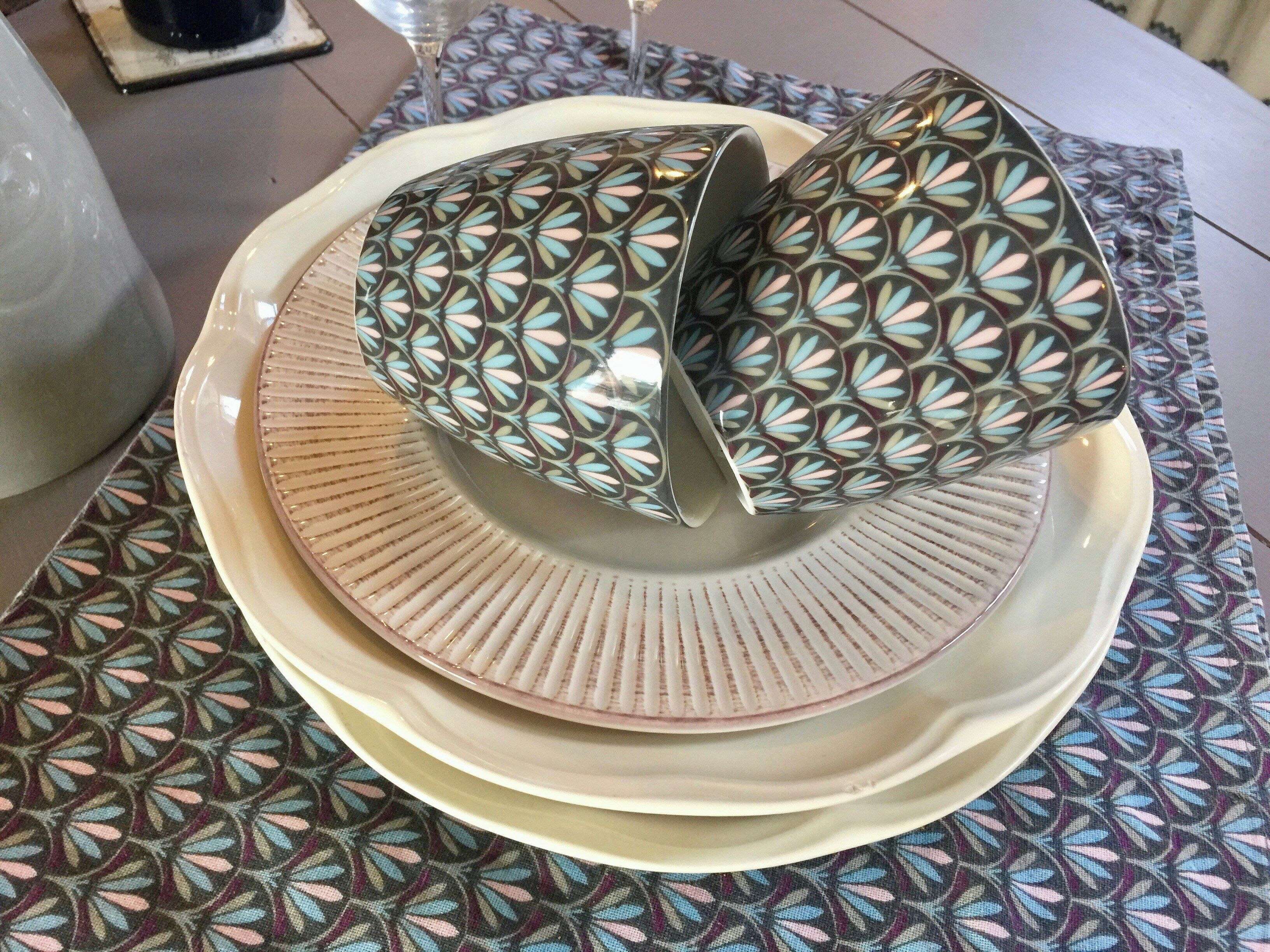 Un ensemble d’assiettes décorées et un bol posés sur une table.