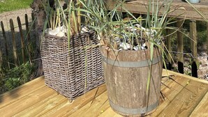 A wooden table with potted plants and a wicker basket. - Nature-close home near beach at Limfjorden (Thyholm)