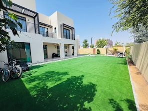 A modern building with a flat roof, large windows, and a well-maintained lawn.