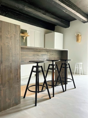Un angolo cottura con un tavolo di legno e sgabelli neri.